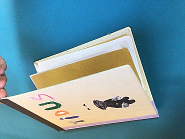 Selbst erstelltes Buch eines Schülers. Der Schüler hat seinen Namen und eine Super Mario-Figur auf die Vorderseite des Buches geklebt.