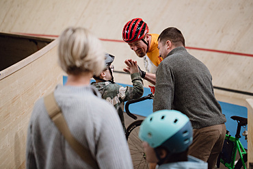 Ein Radprofi klatscht mit einem Schüler ein nach der wilden Fahrt. 