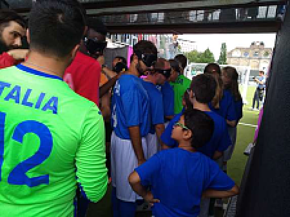 Die Blindenfußballer und die Einlaufender stehen im Spielertunnel. 