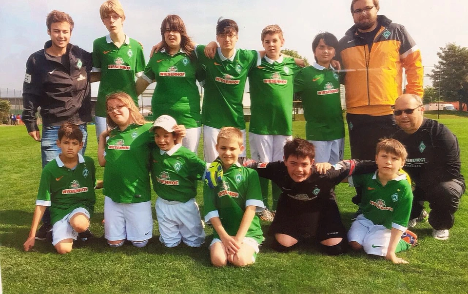 Auf dem Bild sind die gesamte Mannschaft der Fu&szlig;ball AG in ihren Trikots und einige Trainer zu sehen. 