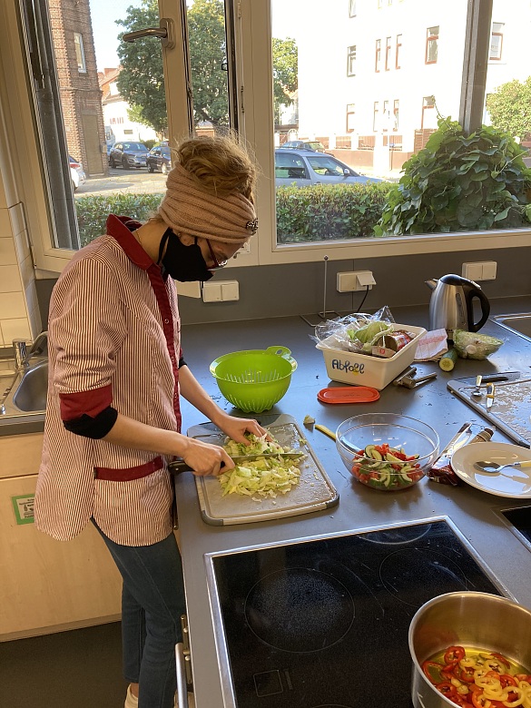 Eine Schülerin schneidet Salat. 