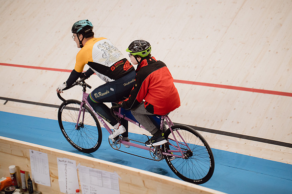 Ein Schüler fährt schnell hinten auf einem Tandem durch die Steilkurve. 