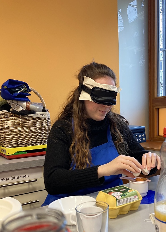 Eine Lehrerin versucht mit Hilfe einer Eiertrenners das Eigelb vom Eiweiß zu trennen. 