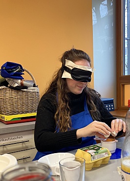 Eine Lehrerin versucht mit Hilfe einer Eiertrenners das Eigelb vom Eiweiß zu trennen. 