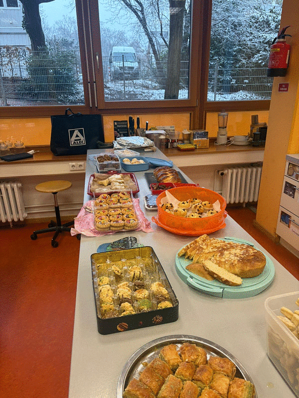 Die Kücheninsel ist reichlich gedeckt mit vielen mitgebrachten Speisen passend zu den Religionen (z.B.: Hefezopf, Datteln und anderes Gebäck) 