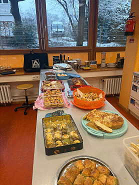 Die Kücheninsel ist reichlich gedeckt mit vielen mitgebrachten Speisen passend zu den Religionen (z.B.: Hefezopf, Datteln und anderes Gebäck) 