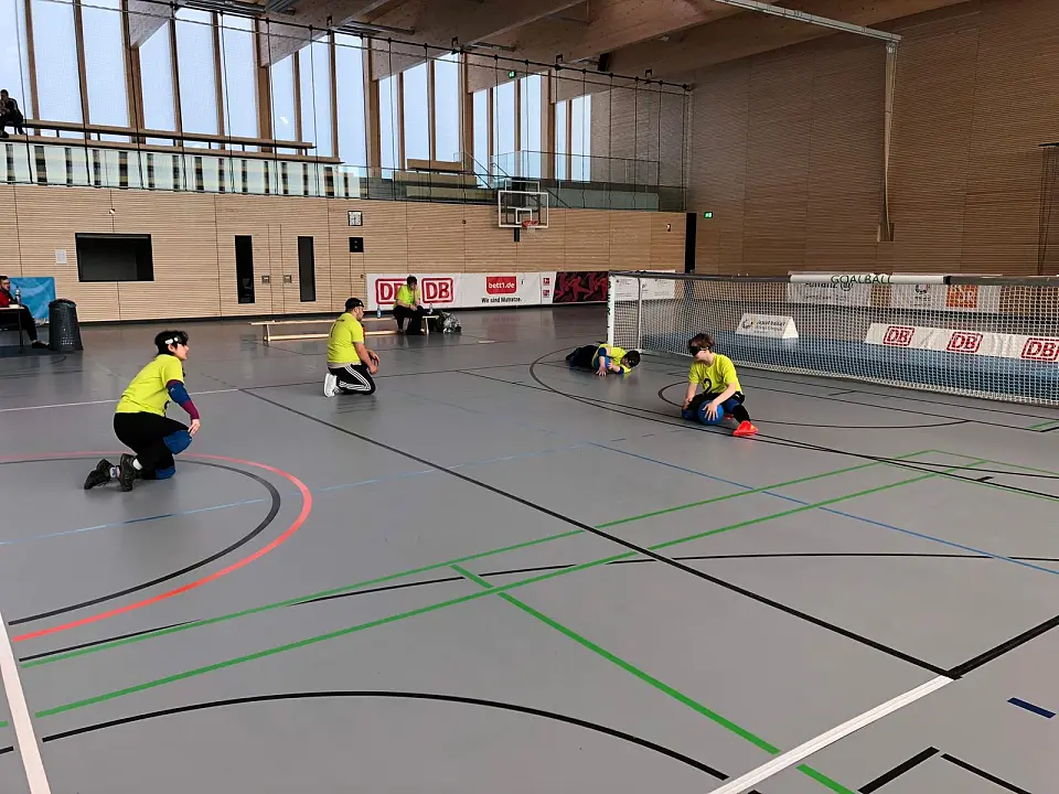 Vier Spieler:innen der GDS sind auf dem Goalballspielfeld. 