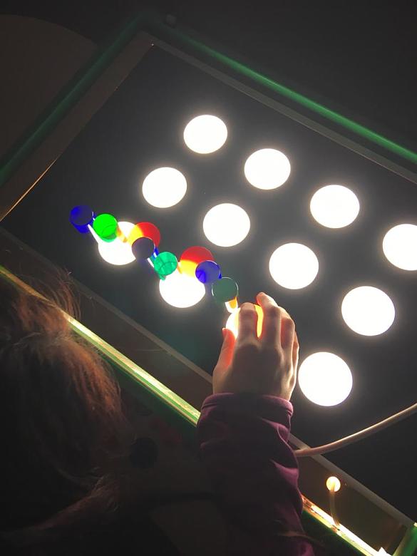 Ein Mädchen macht Aufgaben an einer Lightbox. 