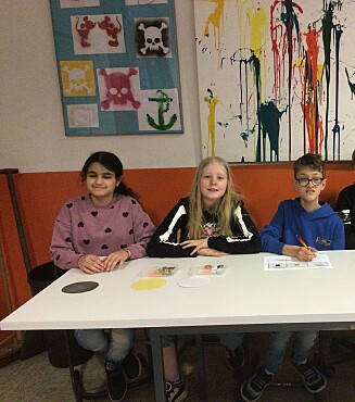 Drei Schüler:innen beim Verkauf der Wertmarken 
