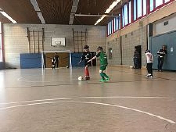 Zwei blinde Schüler*innen kämpfen um den Ball.