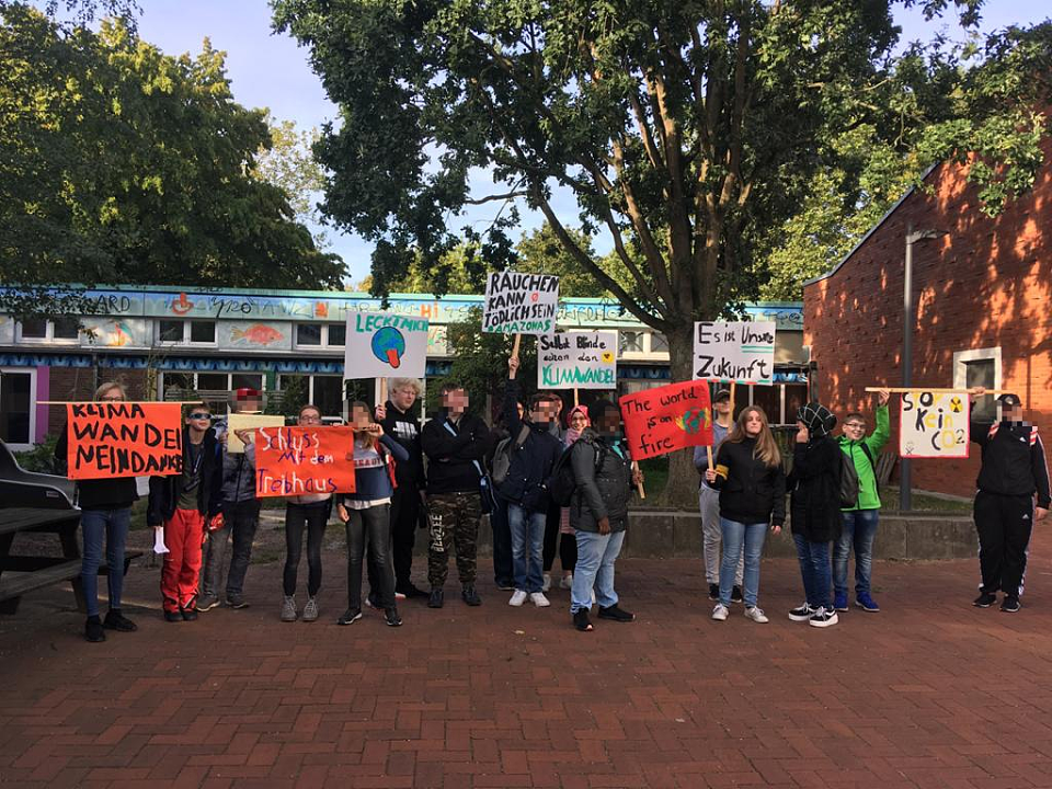Sch&uuml;ler*innen posieren mit ihren Plakaten f&uuml;r "Fridays for future". 