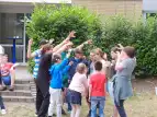 Während einer Sportrallye stehen mehrere Schüler*innen und Lehrkräfte im Kreis beieinander. Sie lachen und haben die Arme gehoben. 